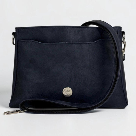 May include: A navy blue crossbody bag with a front pocket and a long, adjustable strap. The bag features a silver-colored clasp and a small, round emblem on the front. The bag is made of a textured material.
